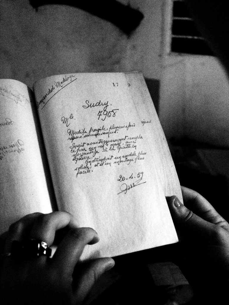 Photo en noir et blanc. On y voit un vieux livre ouvert ou les mains d'une femme le feuillette. Photo réalisée par Benjamin JAN photographe à Rennes